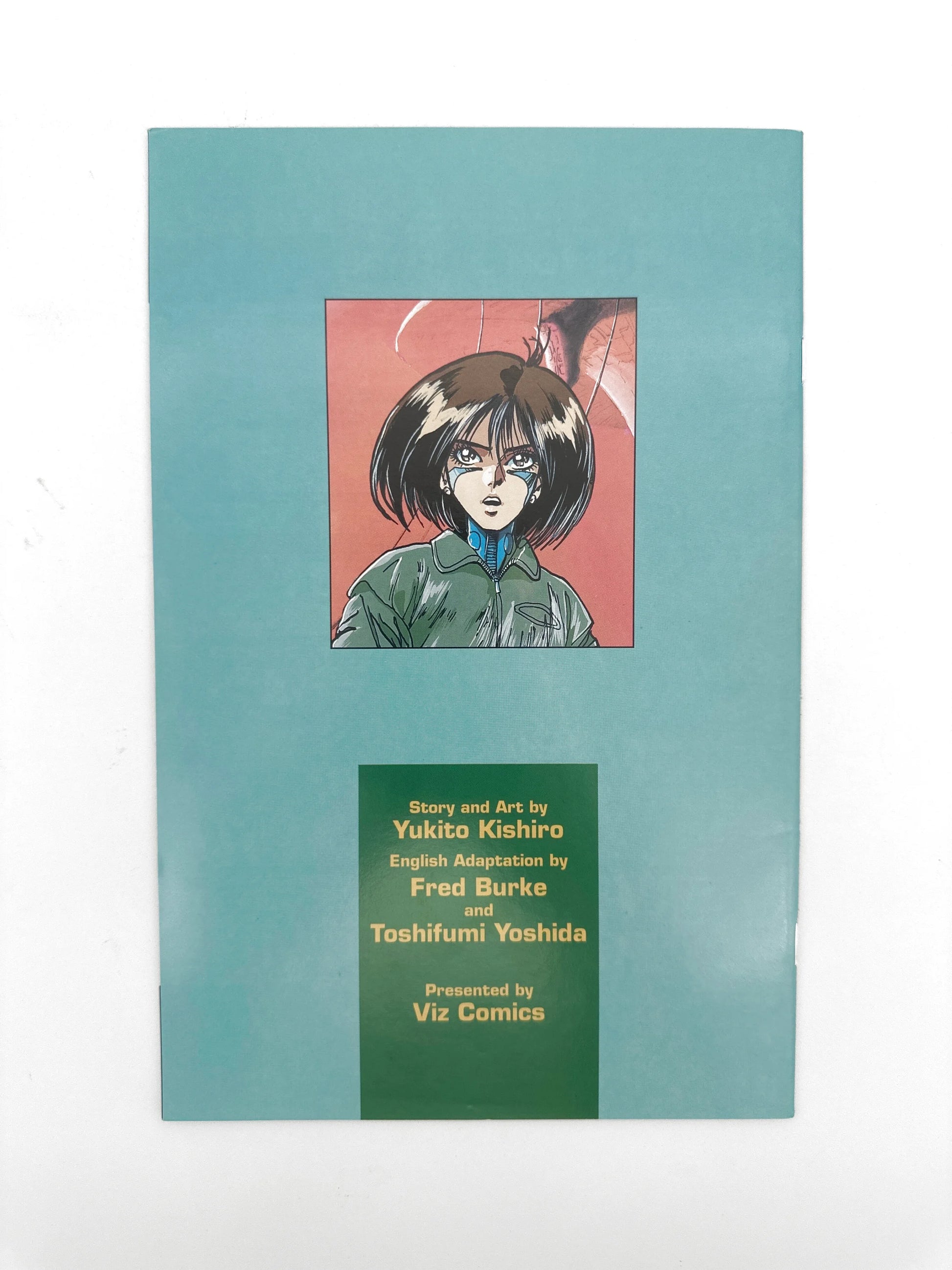 A teal-colored manga comic book with a central illustration of a dark-haired character and production credits