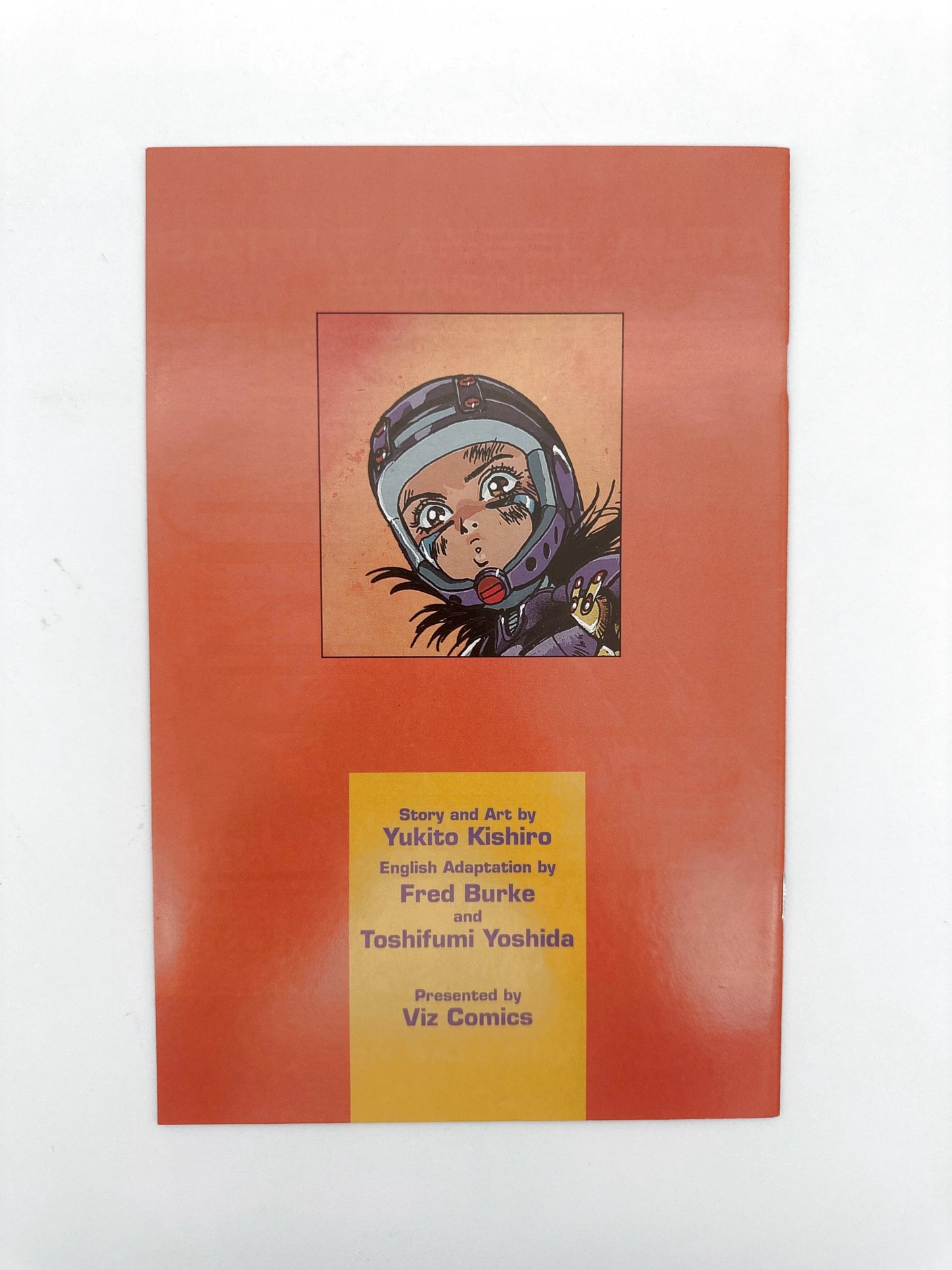 A manga comic book with an orange cover featuring a character’s face in a helmet and text detailing the story, art, and adaptation credits
